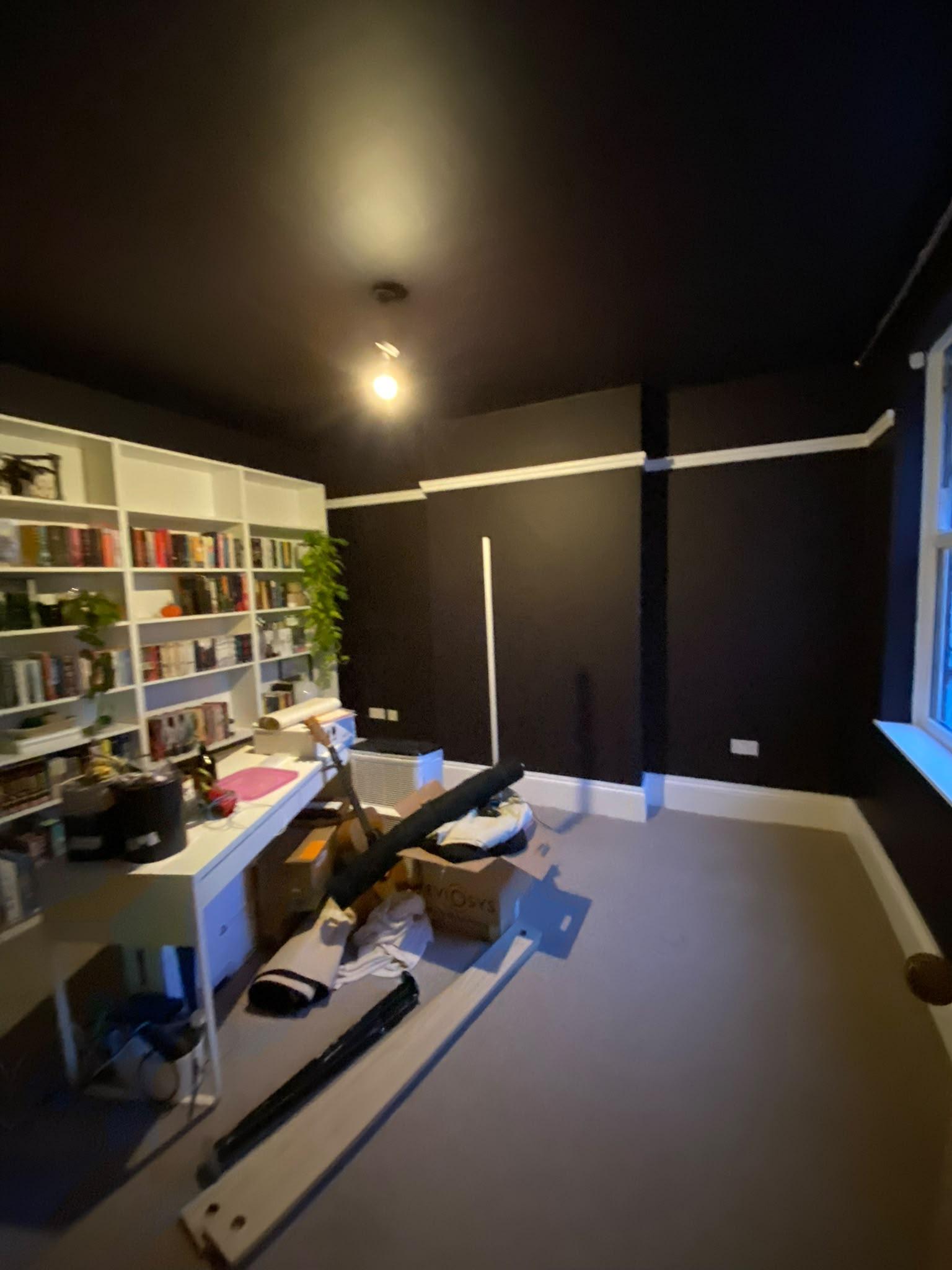 Study painted near black with a white bookcase, skirting and picture rail