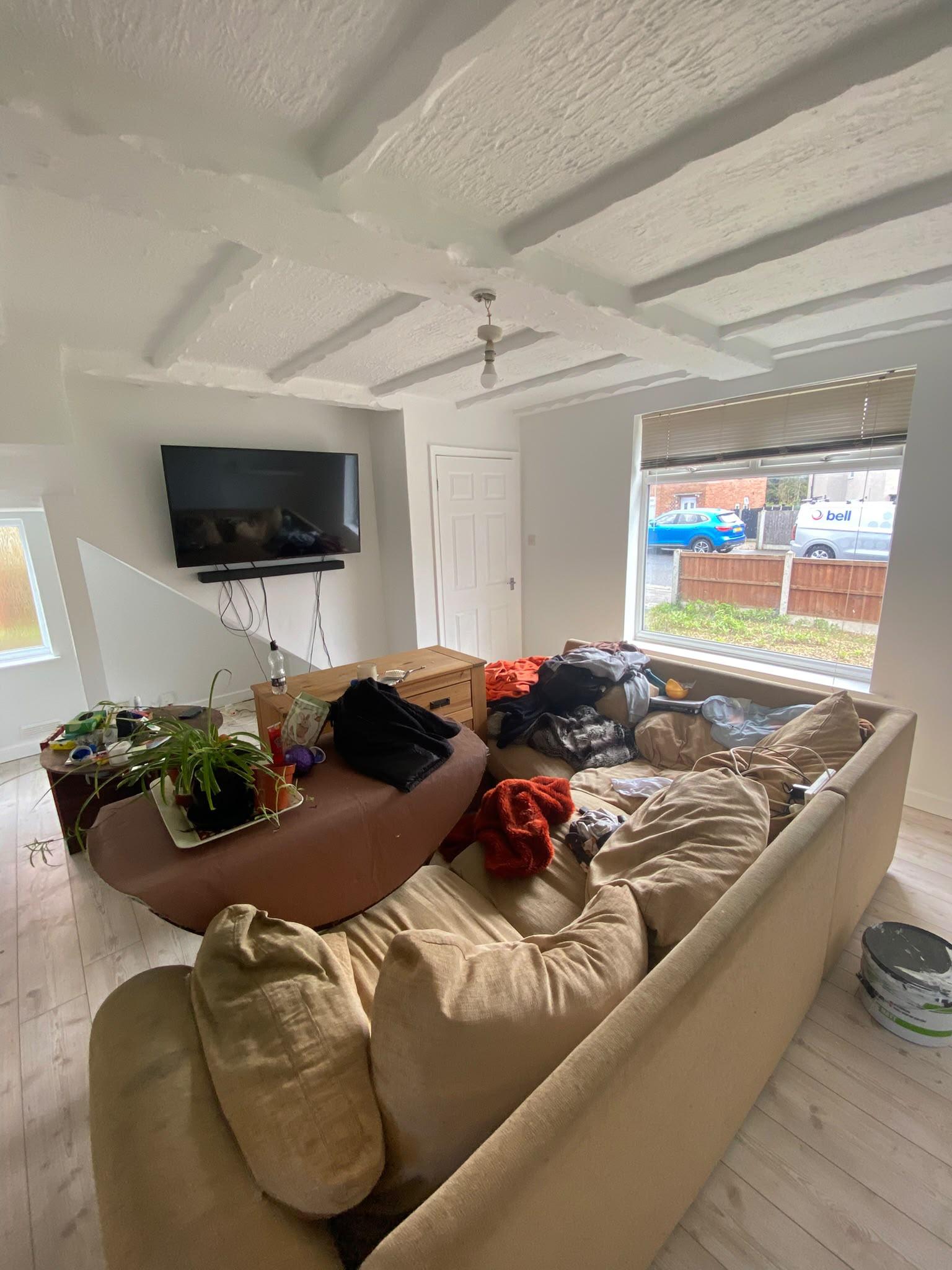 Cottage living room with a white painted beamed ceiling and pale grey walls
